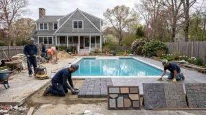 New England backyard pool with resurfaced concrete and paver deck